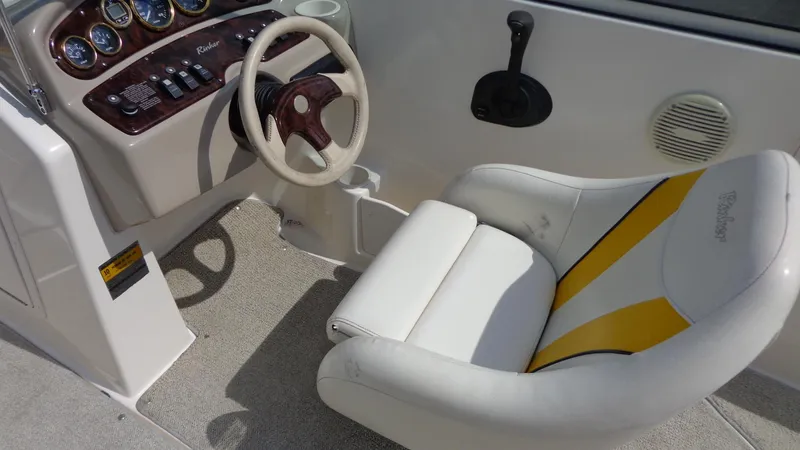 Slide: The Image of 2002 Rinker 212 Captiva Bowrider cockpit with steering wheel and captain's chair. - 9