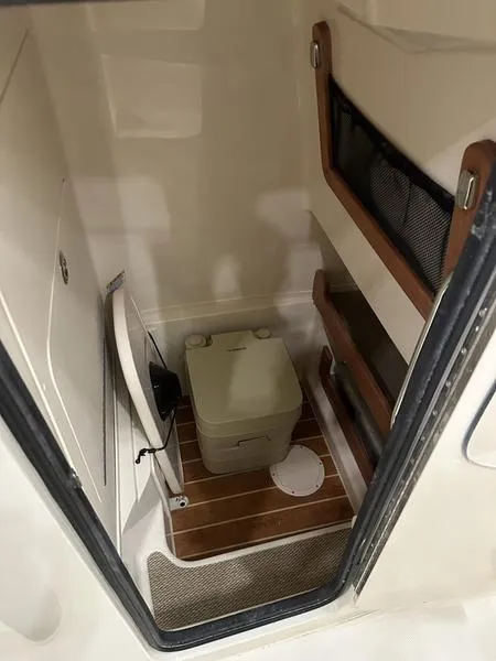 Slide: The Image of 2025 Grady-White Fisherman 257 boat interior with compact toilet and storage. - 14
