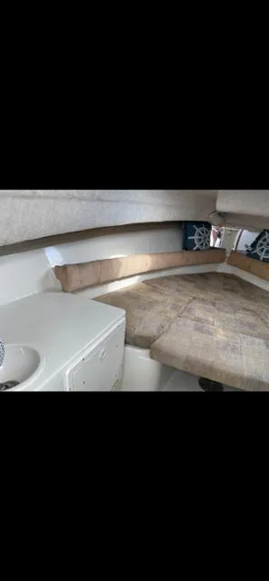 Slide: The Image of 2004 Seaswirl Striper boat interior with cushioned seating and small sink. - 21