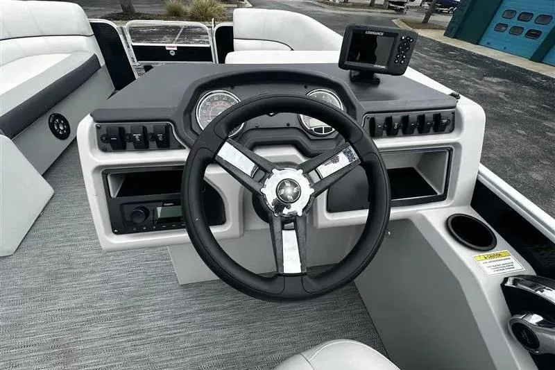 Slide: The Image of 2023 Godfrey 2286 boat dashboard with steering wheel and navigation system. - 11