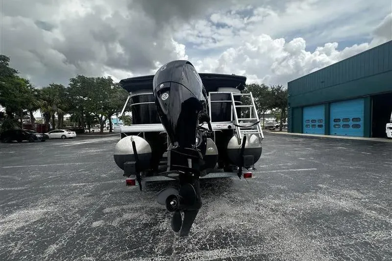 Slide: The Image of 2023 Godfrey 2286 boat with outboard motor in parking lot, cloudy sky background. - 7