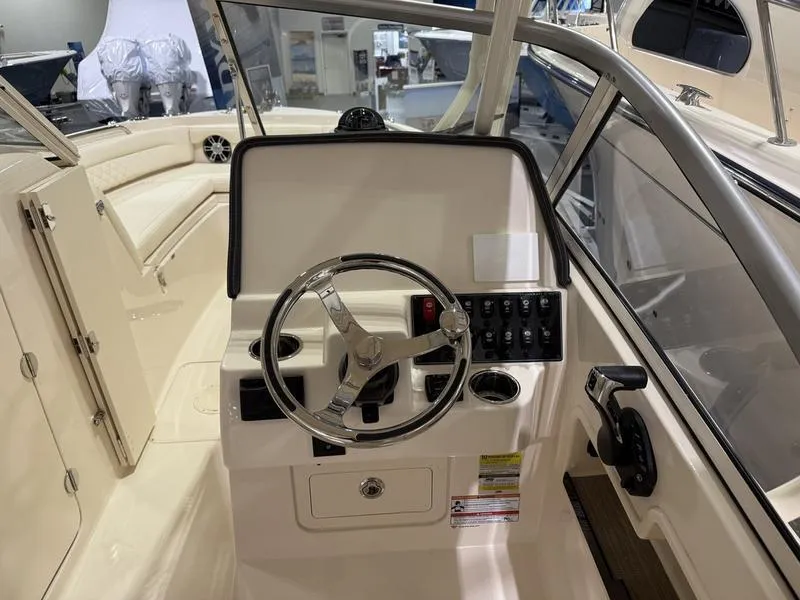 Slide: The Image of 2025 Grady-White Freedom 235 boat interior with steering wheel and control panel. - 6