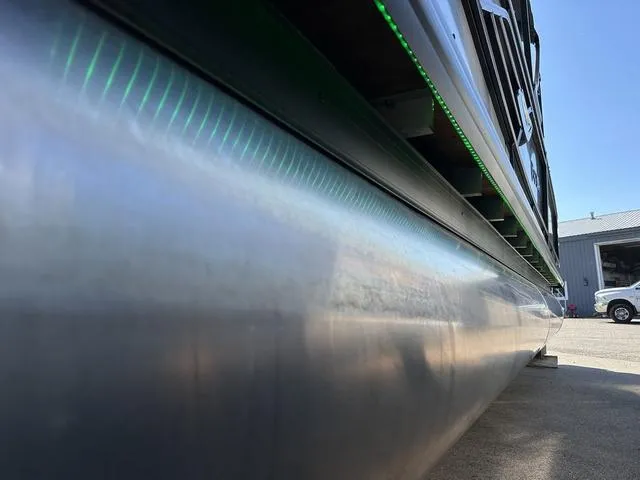 Slide: The Image of 2025 Godfrey AP 255 SBC pontoon boat with canopy, parked outdoors on a sunny day. - 27