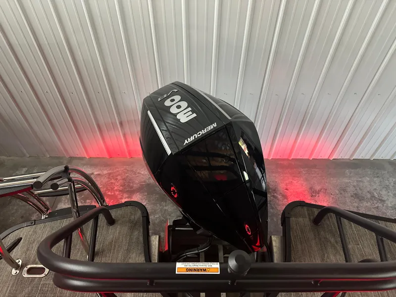 Slide: The Image of 2025 Godfrey AP 255 SBC pontoon boat in a wooden boathouse, featuring sleek design and Mercury branding. - 4