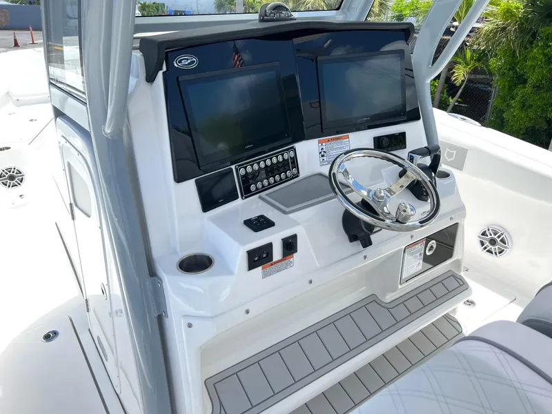 Slide: The Image of 2025 Sea Fox 328 Commander boat helm with dual screens and steering wheel. - 47