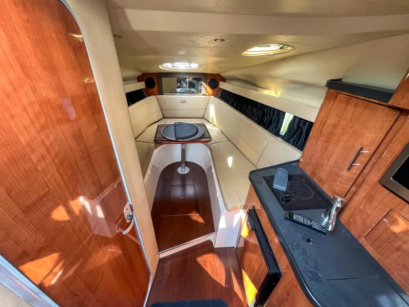 Slide: The Image of 2012 Regal 28 Express cabin interior with wood finishes and seating area. - 10