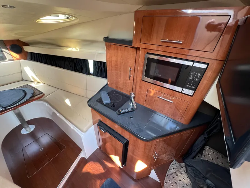 Slide: The Image of Interior of 2012 Regal 28 Express boat with kitchenette and seating area. - 11