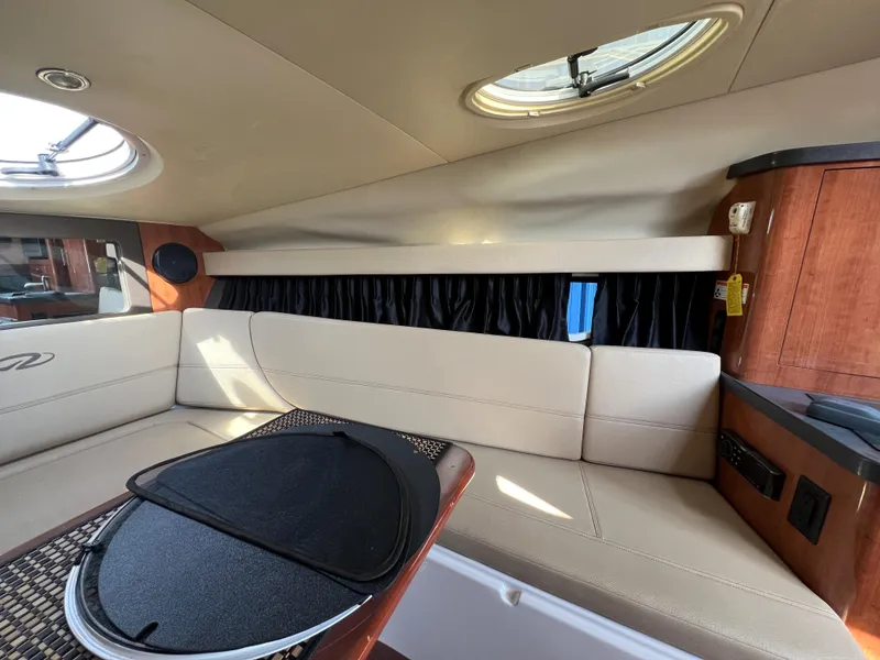 Slide: The Image of Interior of 2012 Regal 28 Express boat with beige seating and wooden accents. - 13