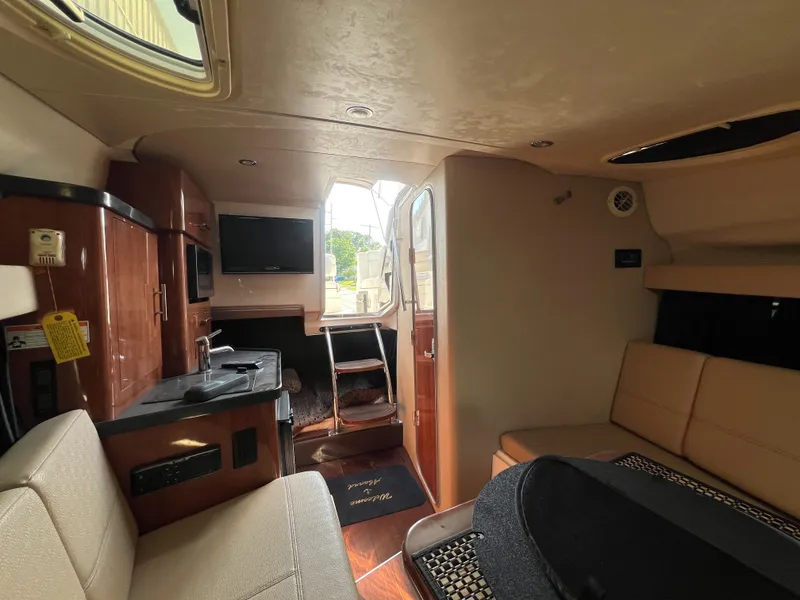 Slide: The Image of Interior of 2012 Regal 28 Express boat with seating, kitchenette, and TV. - 14