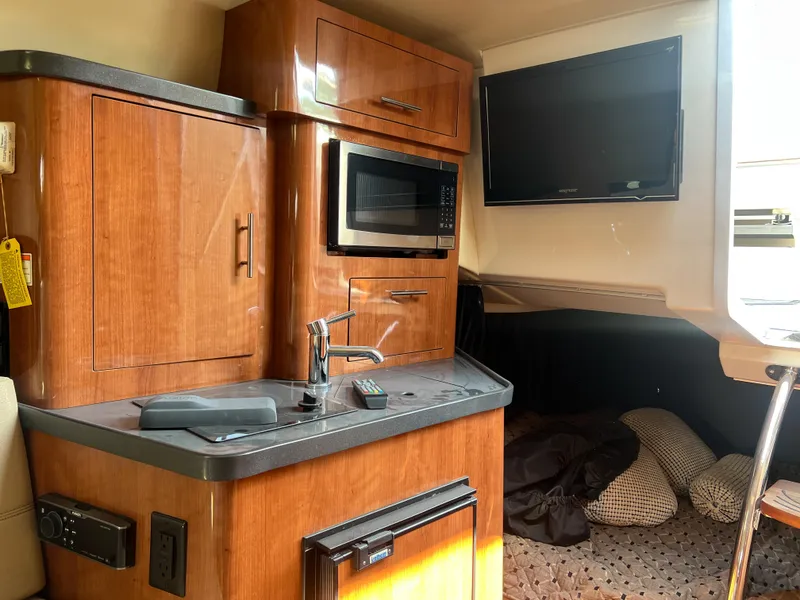 Slide: The Image of Interior of a 2012 Regal 28 Express boat with kitchenette and TV. - 16