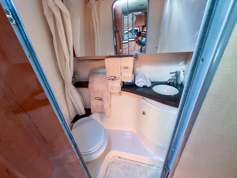 Slide: The Image of 2012 Regal 28 Express bathroom with sink, mirror, and towels. - 18