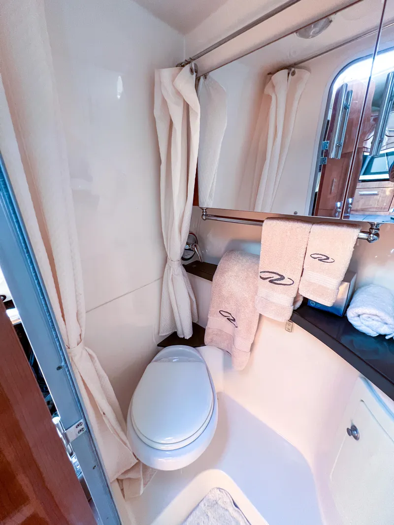 Slide: The Image of Bathroom interior of 2012 Regal 28 Express boat with towels and toilet. - 19