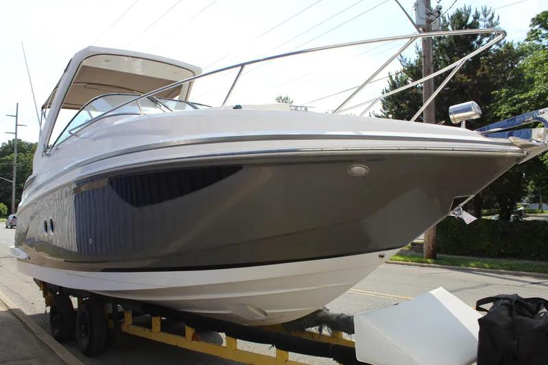 Slide: The Image of 2012 Regal 28 Express boat on trailer, parked on street, side view. - 2