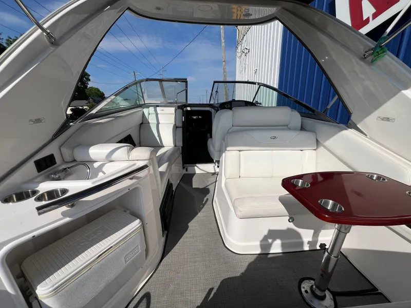 Slide: The Image of 2012 Regal 28 Express boat interior with seating, table, and kitchenette. - 21