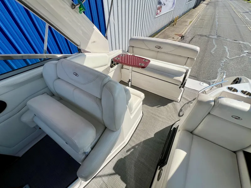 Slide: The Image of 2012 Regal 28 Express boat interior with white seating and a small table. - 22
