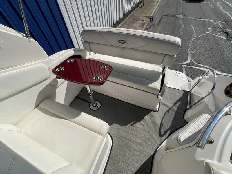 Slide: The Image of 2012 Regal 28 Express boat interior with white seating and a wooden table. - 23