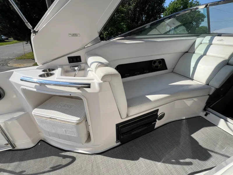Slide: The Image of 2012 Regal 28 Express boat interior with white seating, sink, and cooler storage. - 25