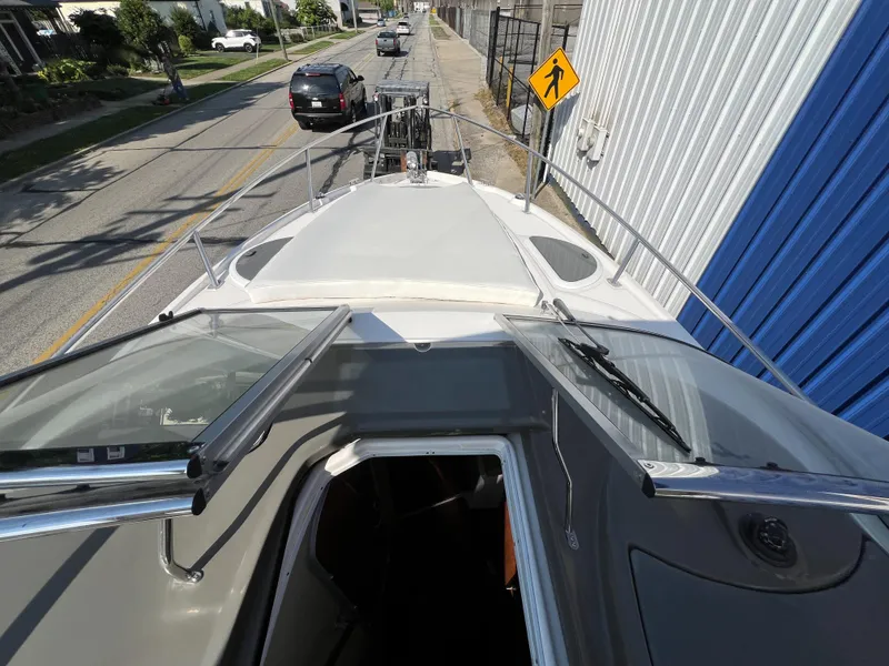 Slide: The Image of 2012 Regal 28 Express boat on trailer, street view with open hatch and windshield. - 26