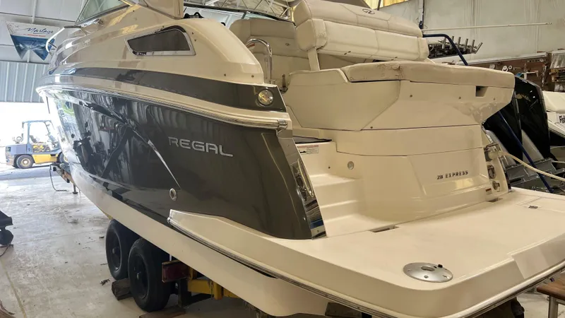 Slide: The Image of 2012 Regal 28 Express boat in a storage facility, showcasing sleek design and spacious deck. - 30