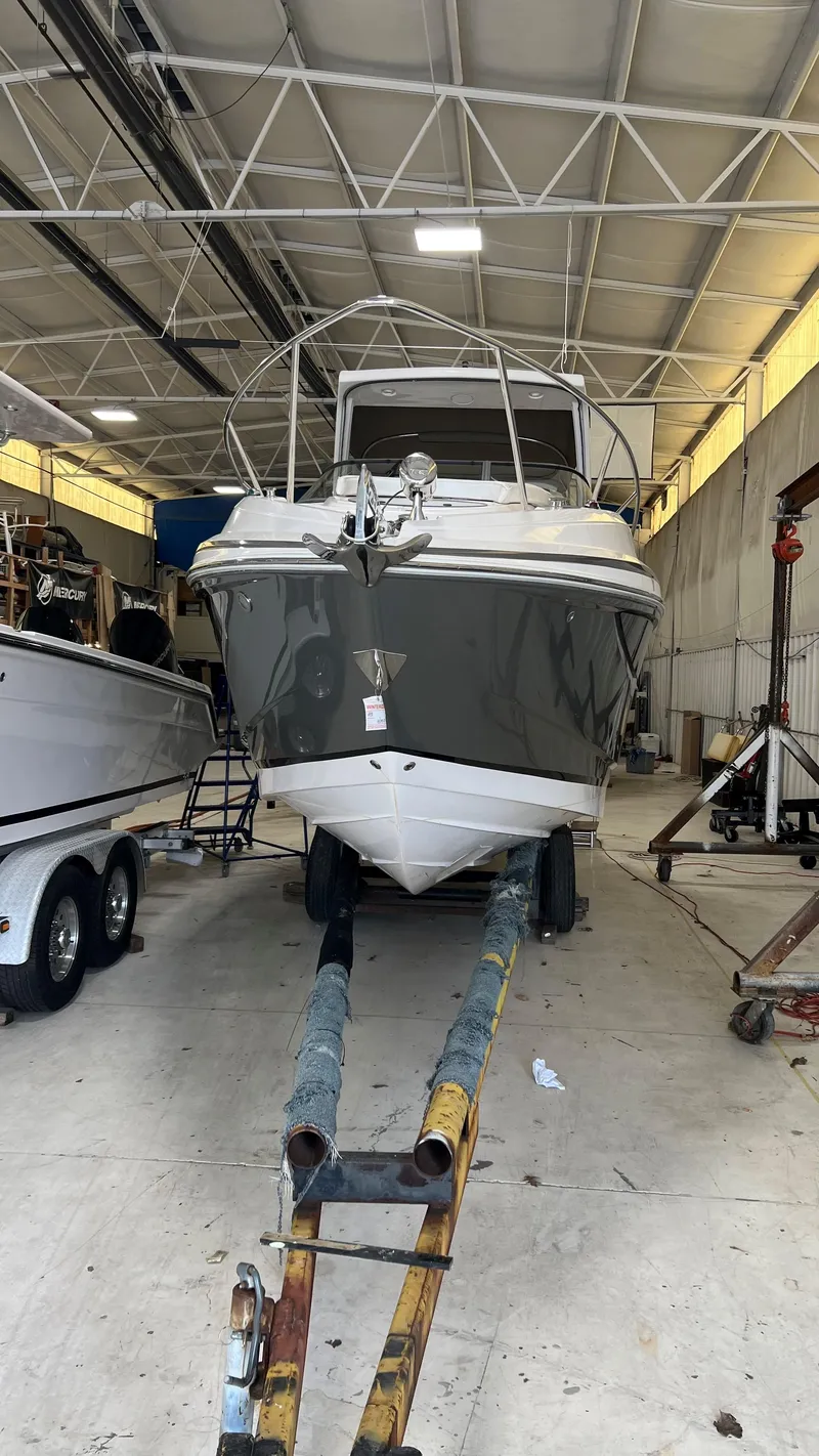 Slide: The Image of 2012 Regal 28 Express boat in a warehouse, front view on a trailer. - 32