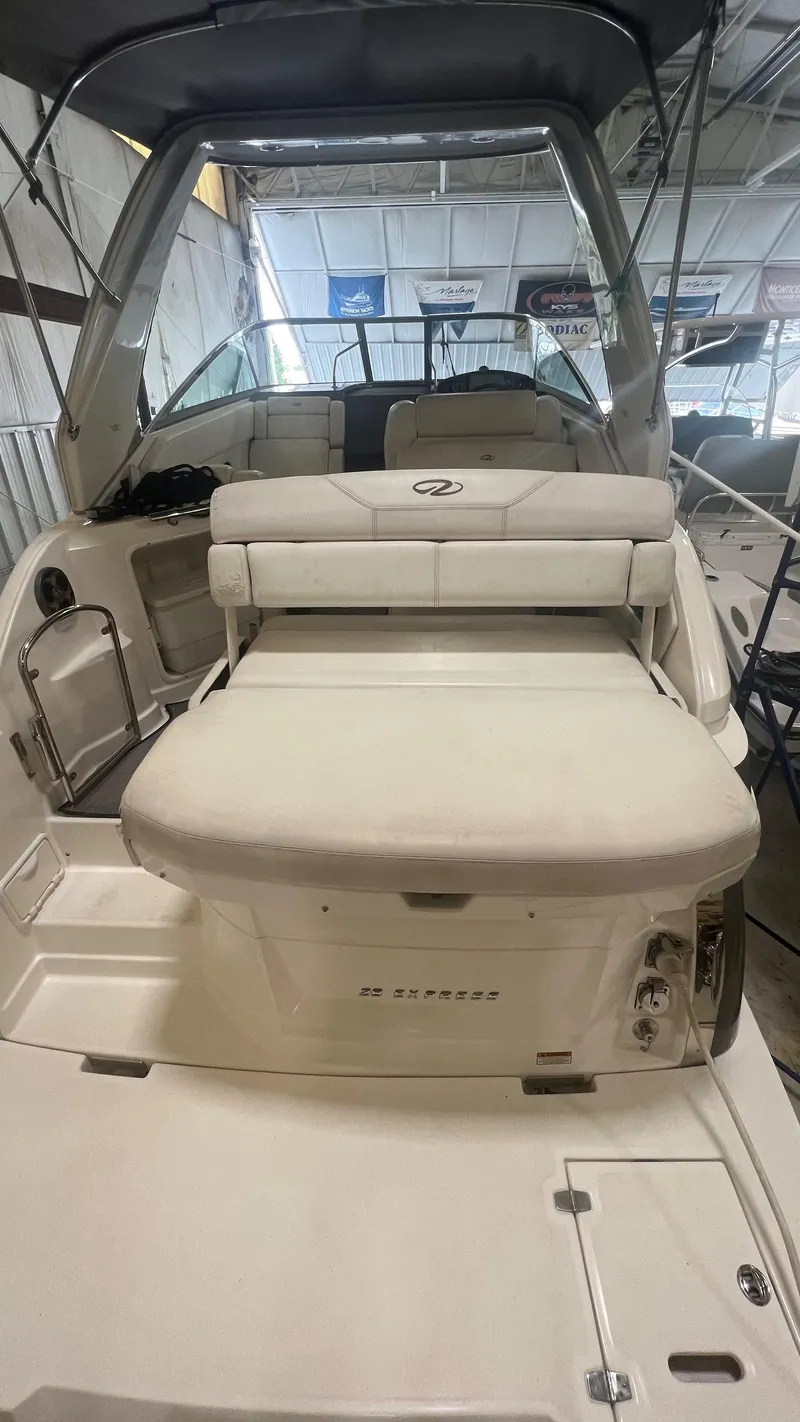 Slide: The Image of 2012 Regal 28 Express boat interior with seating and canopy in a storage facility. - 34