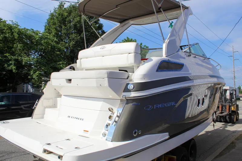 Slide: The Image of 2012 Regal 28 Express boat with sleek design, docked outdoors. - 4
