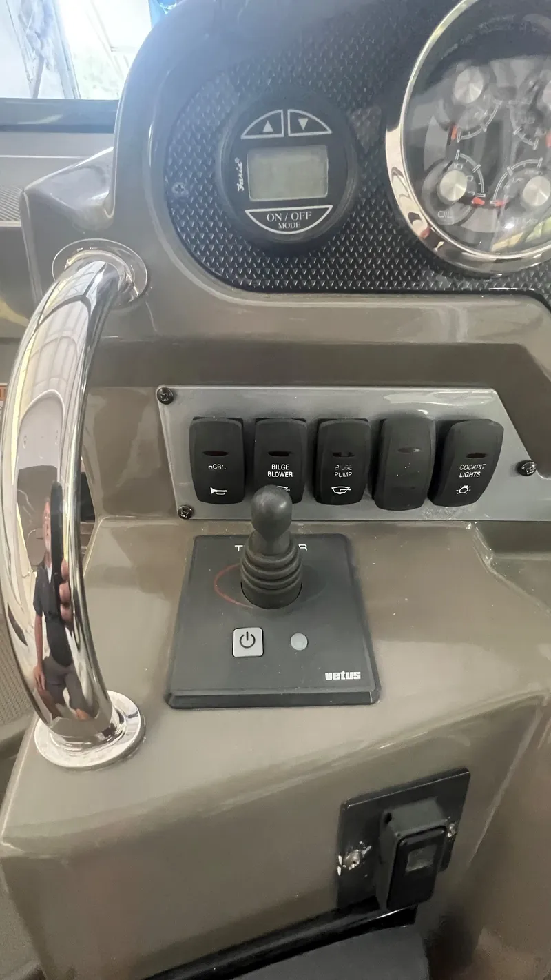 Slide: The Image of Control panel of a 2012 Regal 28 Express boat with joystick and switches. - 42