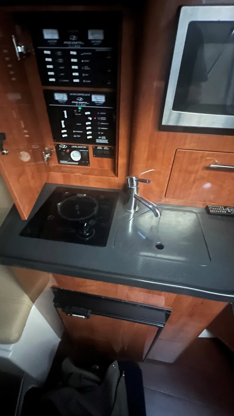Slide: The Image of 2012 Regal 28 Express boat interior with kitchenette, sink, and control panel. - 46