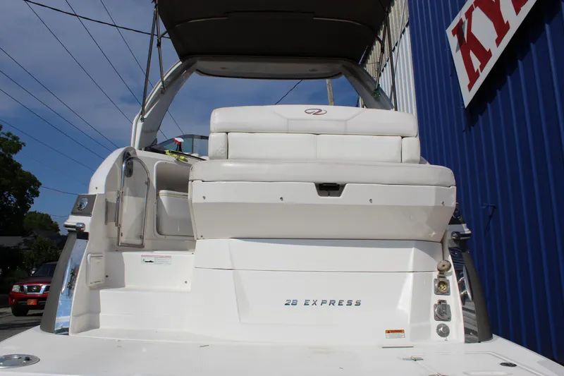 Slide: The Image of 2012 Regal 28 Express boat, rear view, docked near blue building. - 6