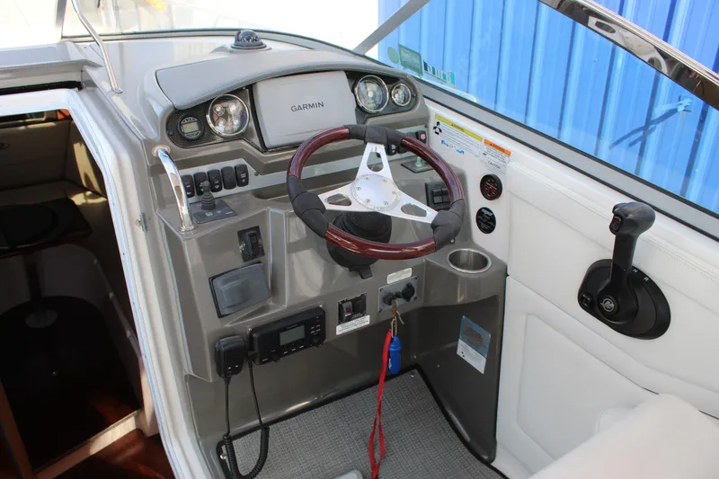 Slide: The Image of 2012 Regal 28 Express boat helm with Garmin navigation and wood-accented steering wheel. - 9