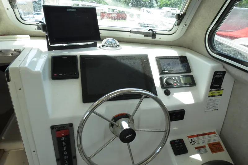 Slide: The Image of 2018 Parker 2520 XLD Sport Cabin boat helm with steering wheel and navigation equipment. - 25