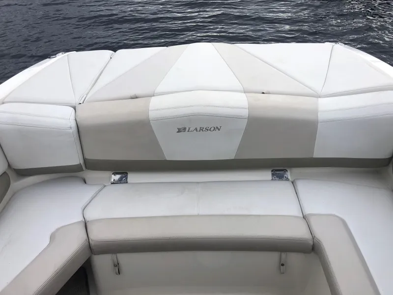 Slide: The Image of 2006 Larson 248 LXI boat interior with white seating and water backdrop. - 10