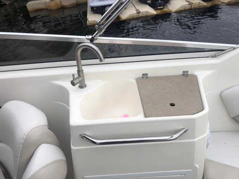 Slide: The Image of 2006 Larson 248 LXI boat sink and countertop detail by the water. - 12