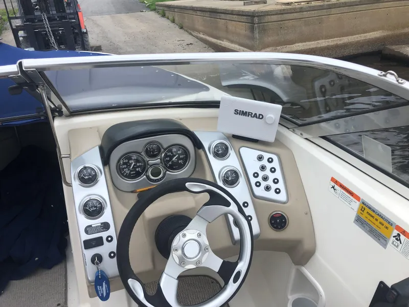Slide: The Image of 2006 Larson 248 LXI boat dashboard with steering wheel and Simrad navigation system. - 7