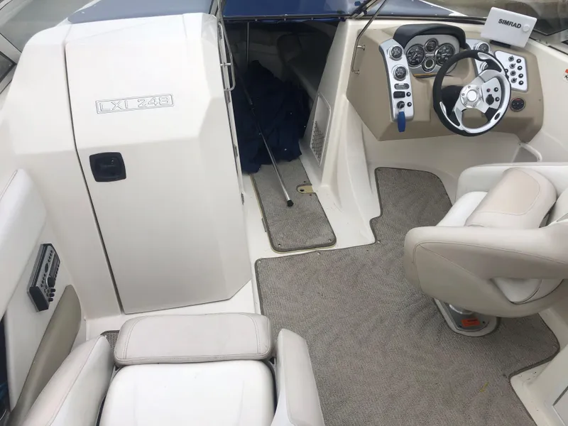 Slide: The Image of Interior of 2006 Larson 248 LXI boat with steering wheel and seating area. - 9