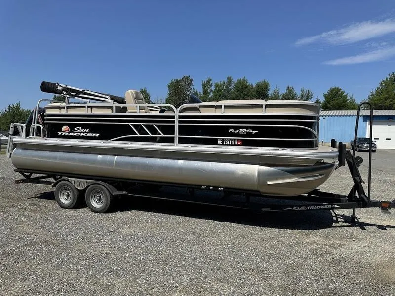 Slide: The Image of 2021 Sun Tracker PB 22 RF pontoon boat on trailer, parked outdoors. - 2