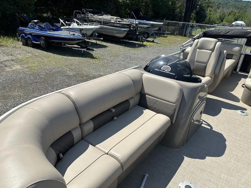 Slide: The Image of 2021 Sun Tracker PB 22 RF pontoon boat with beige seating, parked outdoors. - 8