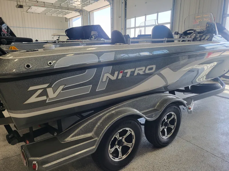 Slide: The Image of 2018 Nitro ZV21 fishing boat on a dual-axle trailer in a garage. - 1