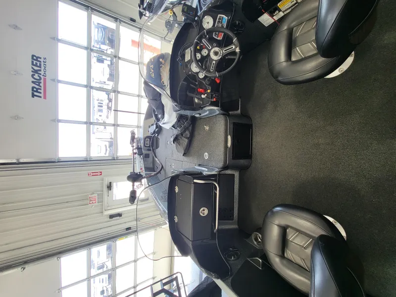 Slide: The Image of 2018 Nitro ZV21 boat interior with steering console and seating in a showroom. - 2
