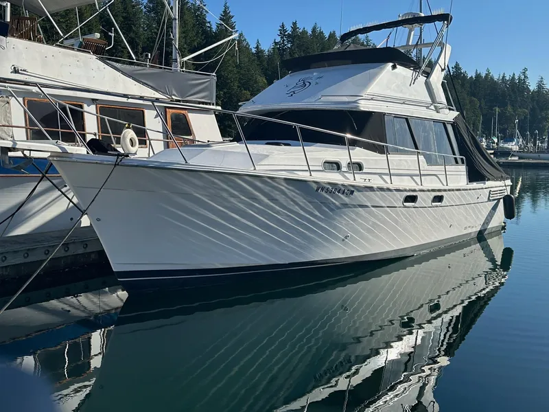 Slide: The Image of 1992 Bayliner 3288 yacht docked in a serene marina setting. - 0
