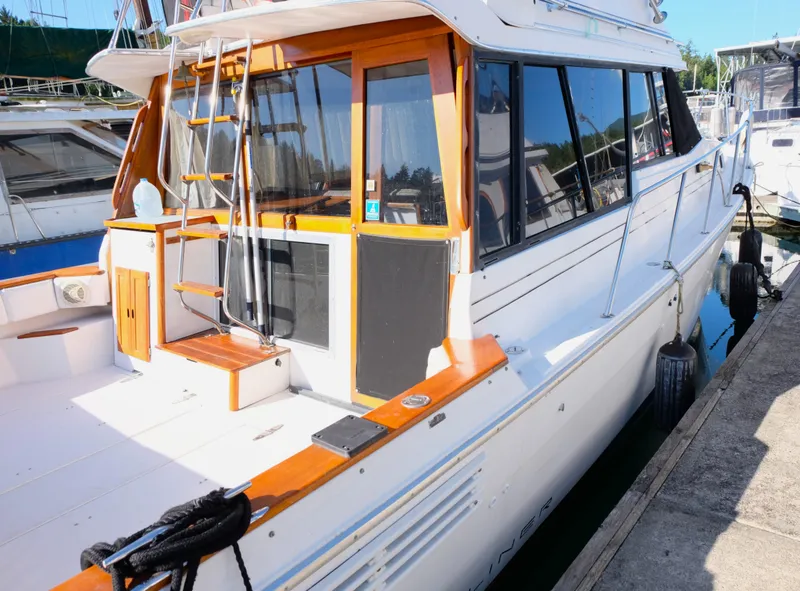 Slide: The Image of 1992 Bayliner 3288 yacht docked, featuring a sleek white exterior and wooden accents. - 1