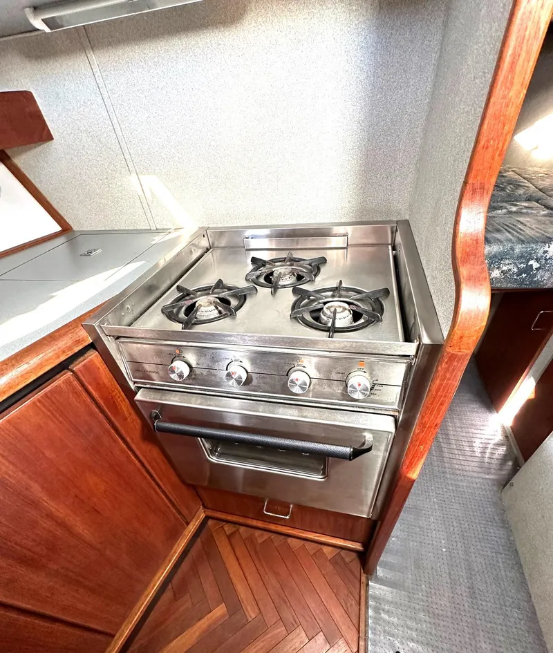 Slide: The Image of 1992 Bayliner 3288 yacht kitchen with stainless steel stove and wooden cabinetry. - 18