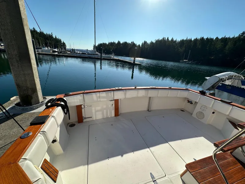 Slide: The Image of 1992 Bayliner 3288 boat docked in a serene marina with calm waters and forested background. - 22