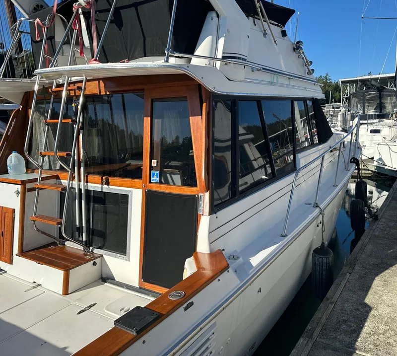 Slide: The Image of 1992 Bayliner 3288 yacht docked at marina, featuring wooden accents and spacious deck. - 26