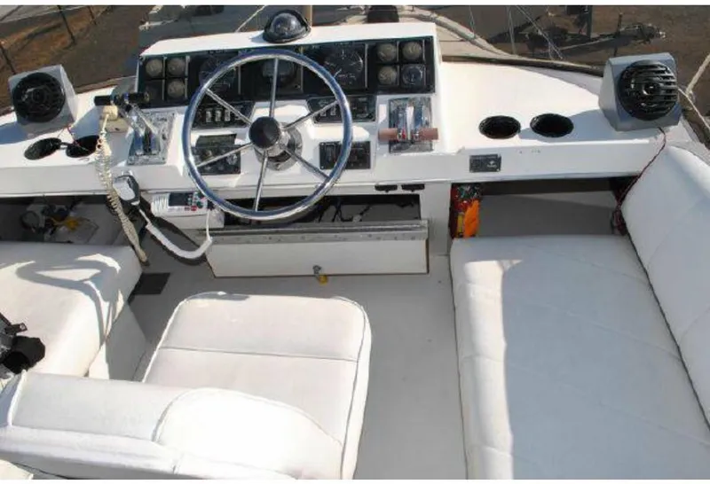 Slide: The Image of 1992 Bayliner 3288 boat cockpit with steering wheel and white seating. - 5