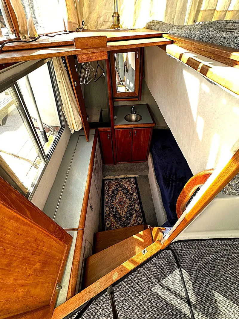 Slide: The Image of 1992 Bayliner 3288 cabin interior with sink, bed, and wooden cabinetry. - 7