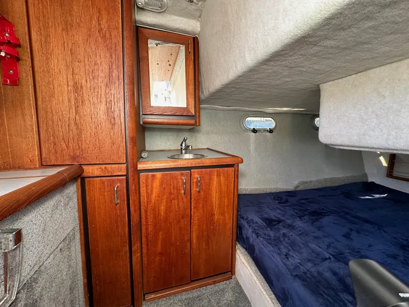 Slide: The Image of 1992 Bayliner 3288 cabin interior with wood cabinetry, sink, and cozy sleeping area. - 8