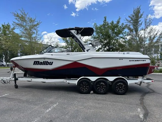 Slide: The Image of 2024 Malibu 25 LSV Wakesetter boat on a trailer in a parking lot. - 5
