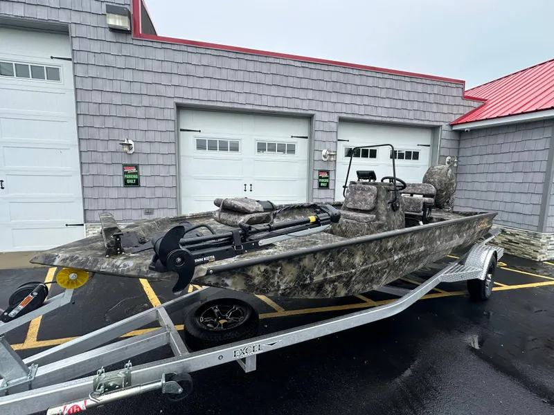 Slide: The Image of 2025 Excel 1960 Stalker CC boat on a trailer outside a garage. - 1