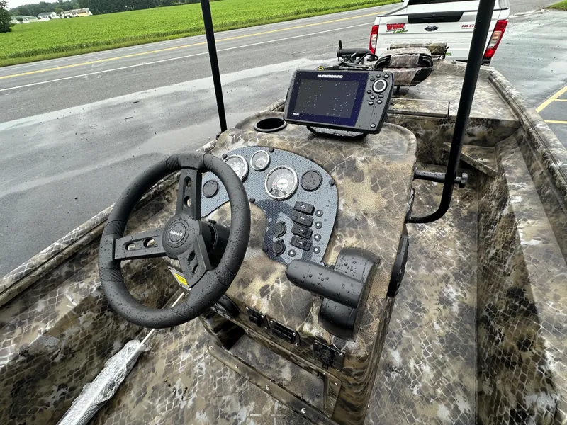 Slide: The Image of 2025 Excel 1960 Stalker CC boat dashboard with steering wheel and navigation system. - 10